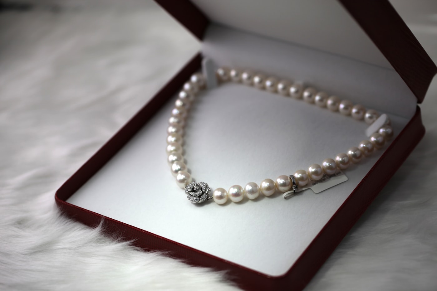 Pearl necklace arranged in a dark jewellery presentation box